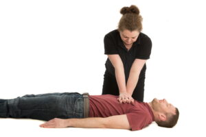 Trainer demonstrating hand placement for CPR on a casualty